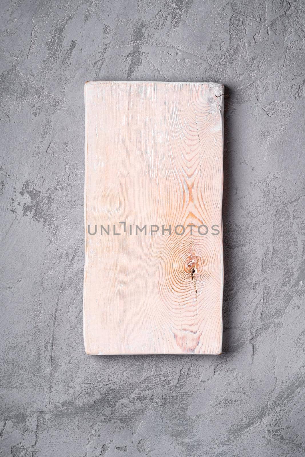 Handcrafted white old wooden cutting board on stone concrete background, top view by Frostroomhead