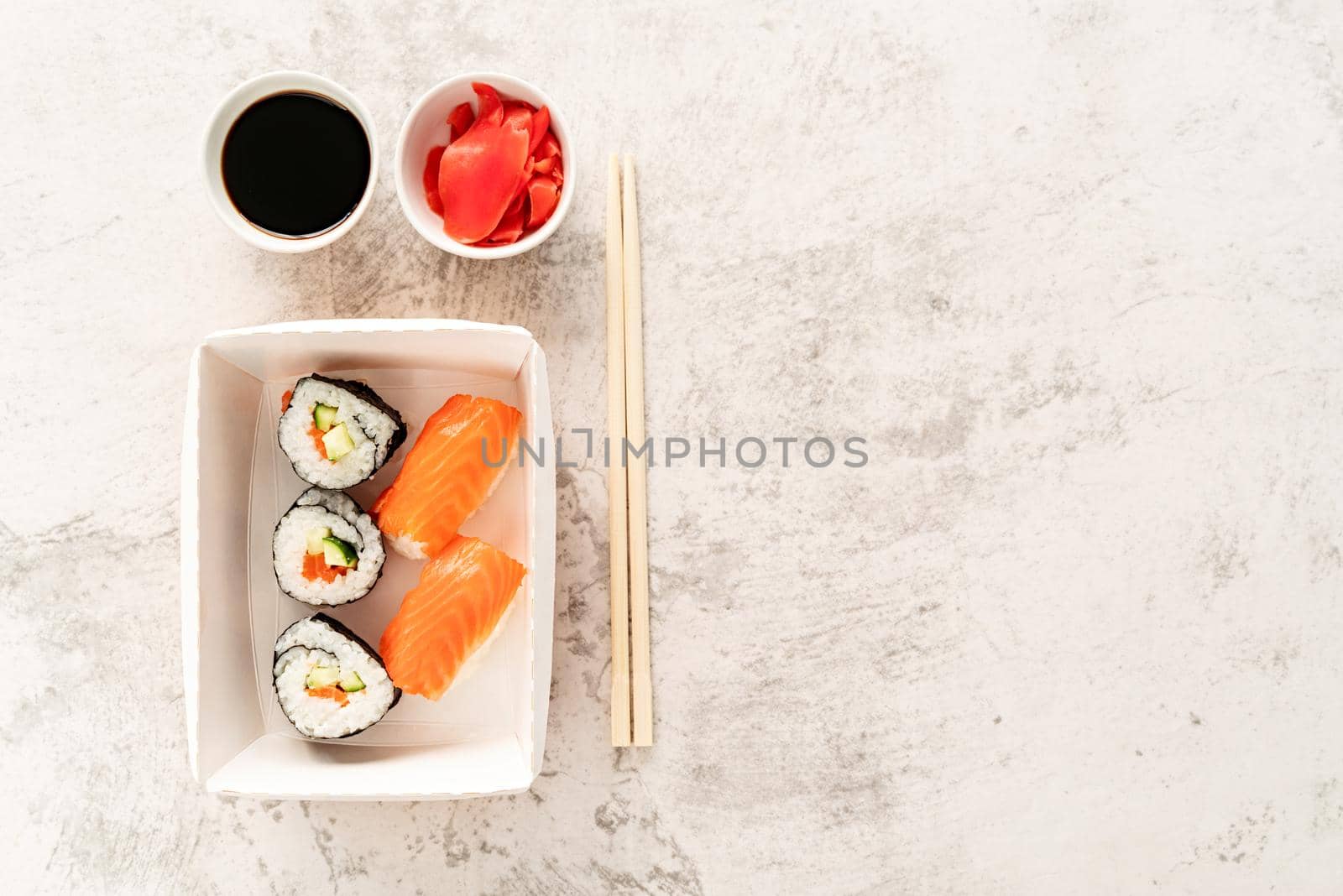 Sushi set with soy souce, ginger and chopstics on white marble background. Top view. Flat lay. by Desperada