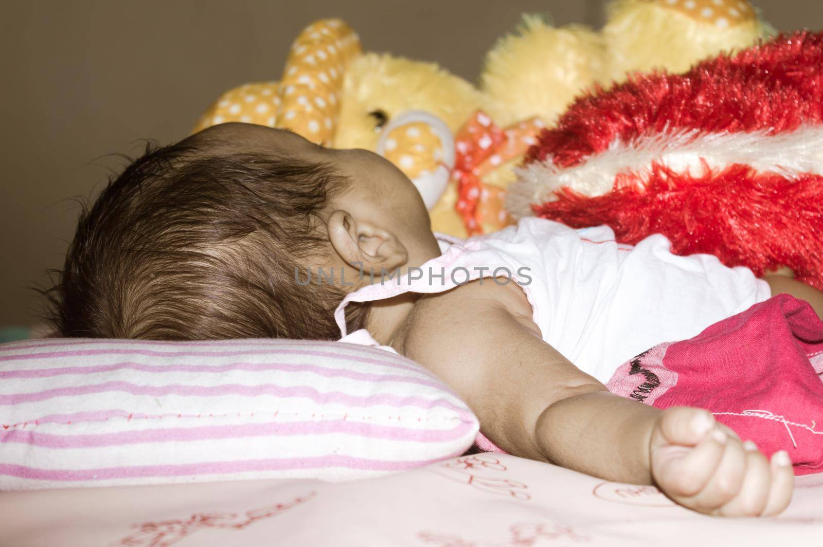 One Sleeping newborn baby boy in sleepy mood lying on bed facing off the camera. Three month old Sweet little infant toddler. Indian ethnicity. Front view. Child care peace tranquil background.
