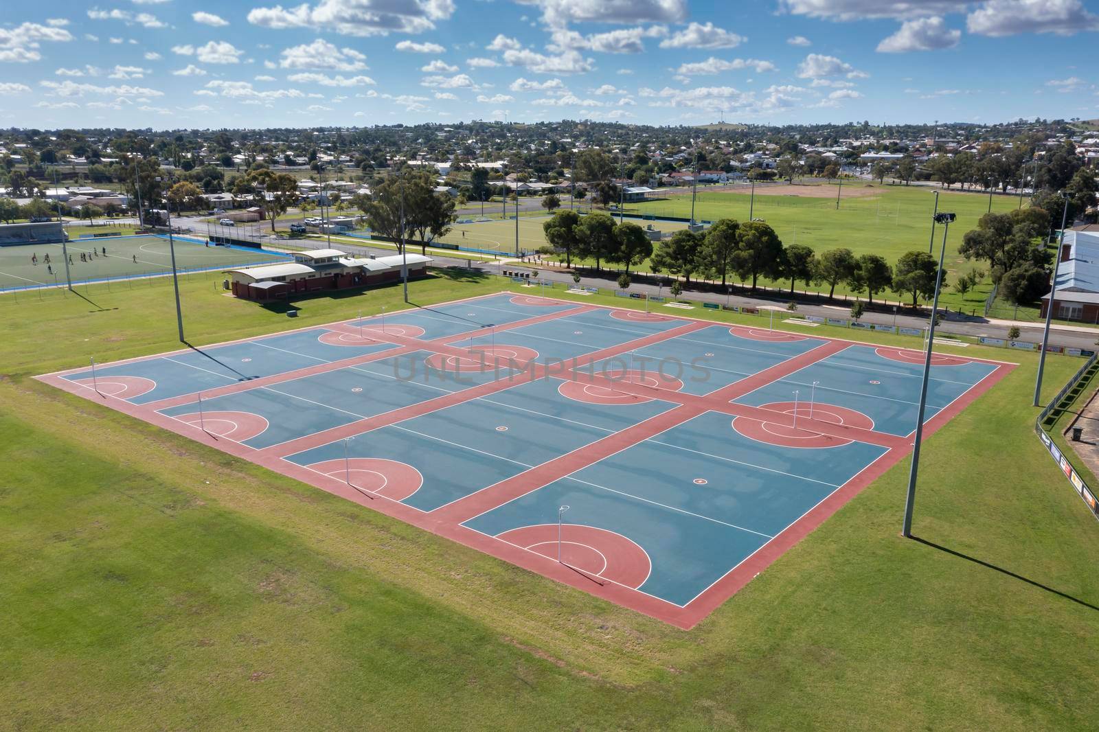 Drone aerial photograph of colourful netball courts and large sports fields in regional New South Wales in Australia