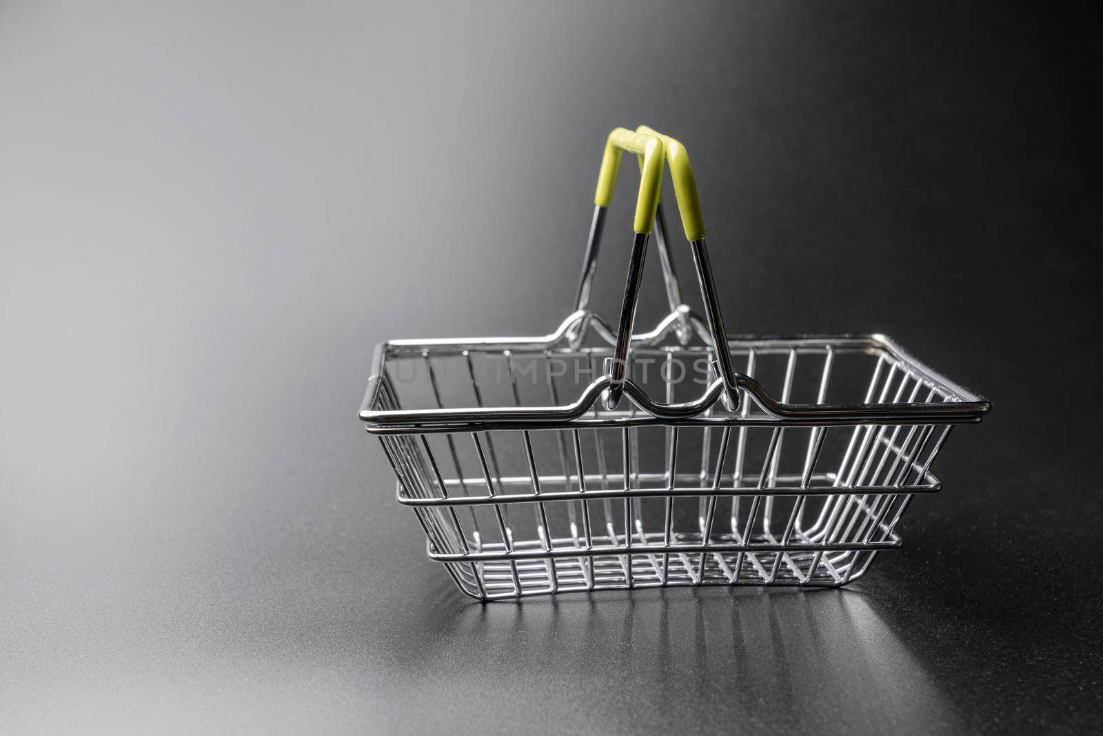 steel supermarket basket on black background close-up. High quality photo