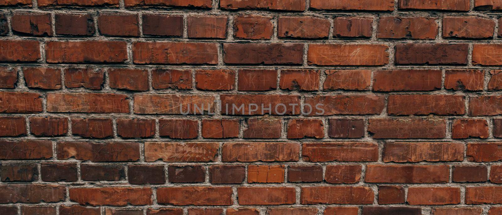 The texture of an old brick wall with natural defects. Scratches, cracks, crevices, chips, dust, roughness, abrasion. Template for design and background.Copy space,banner, wide panorama by Alla_Morozova93