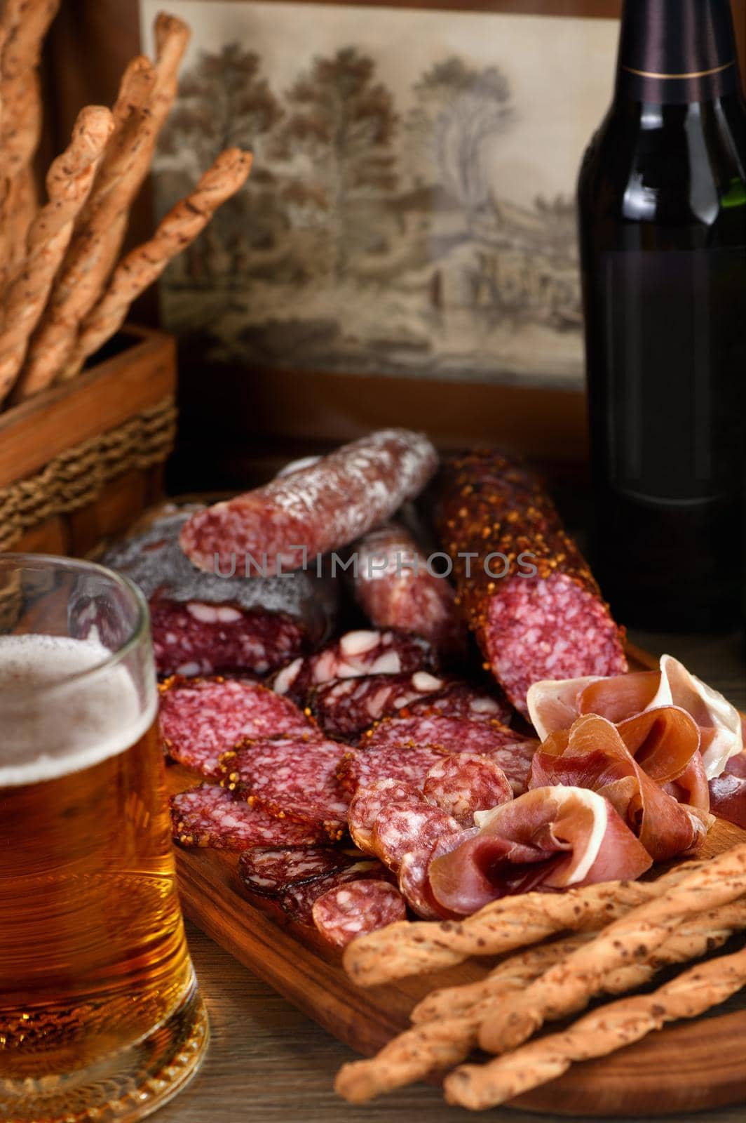 Antipasti dish with bacon, jerky, salami, crispy grissini with cheese. A meat appetizer is a great idea for a beer.