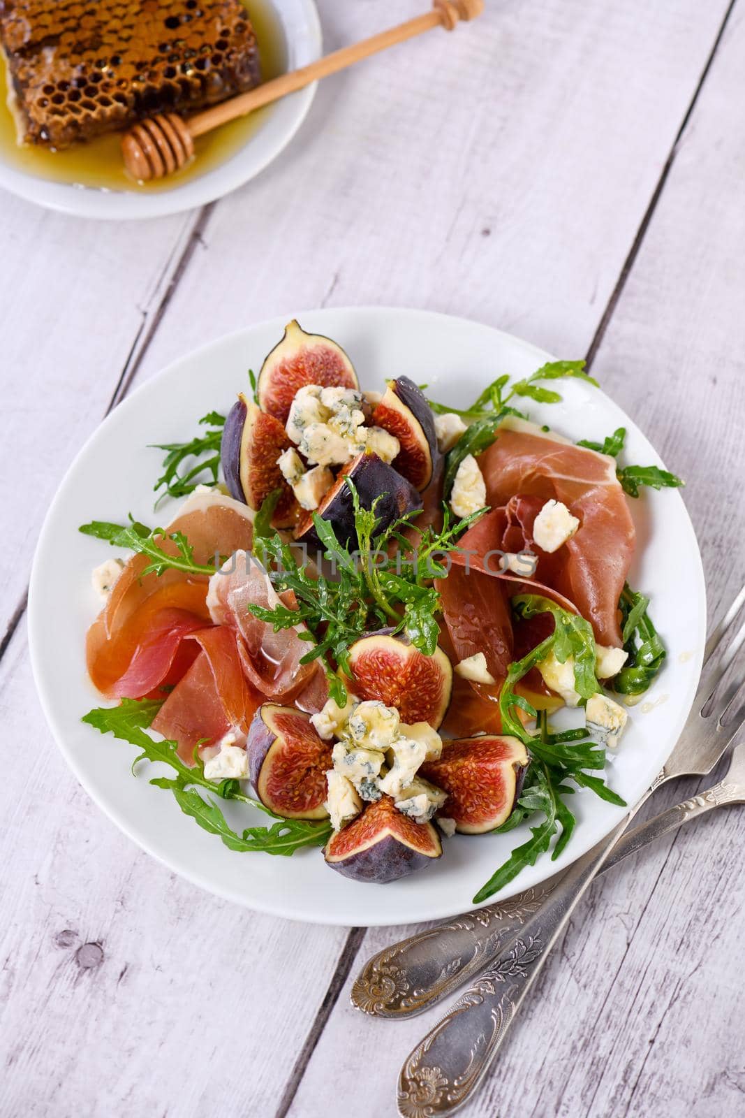 Appetizer arugula with Parma ham and fresh figs stuffed blue cheese, honey