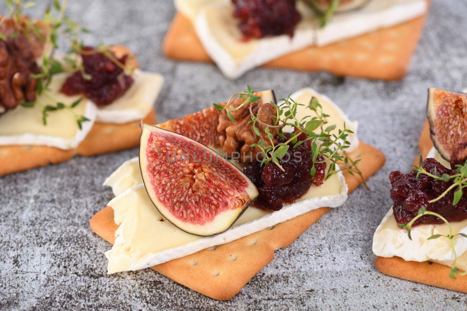 Cracker with a slice of camembert, jam, figs and nuts.
A great snack idea for a holiday, picnic or party.

