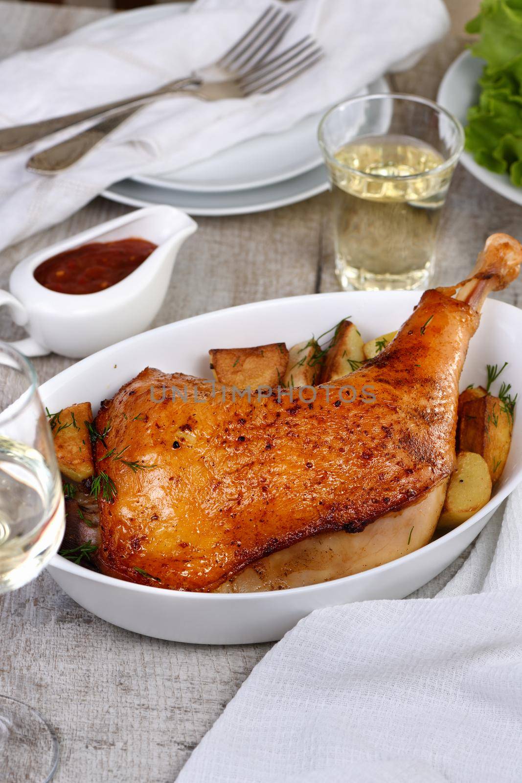 Roasted turkey leg with potatoes on the dinner table