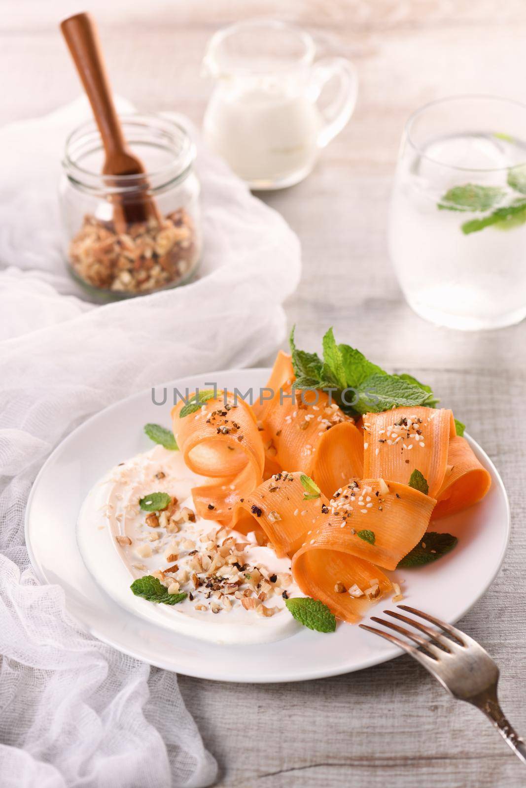 Gluten free vegetarian salad with carrot and yogurt seasoned with crushed nuts and spices, mint castings