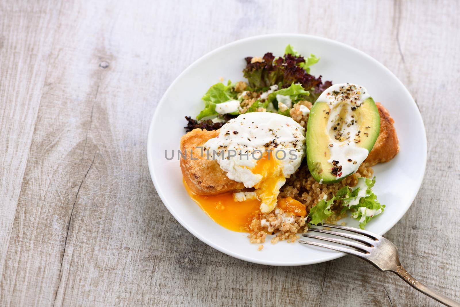 A healthy and balanced breakfast plate.
Benedict's egg spreads on a toasted toast with half an avocado, quinoa and lettuce, seasoned   spices and yogurt dressing. Enjoy the most important meal of the day
