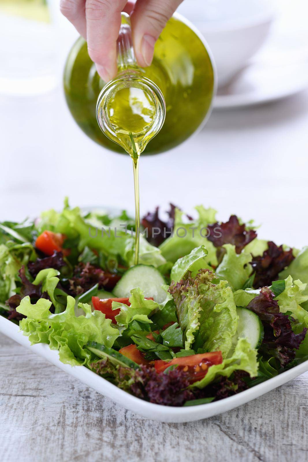 Pour the vegetable salad with lemon - olive dressing from butter-boat