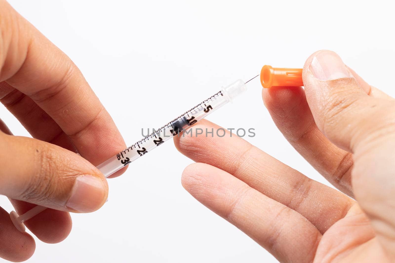 Hand holding an insulin syringe before being used