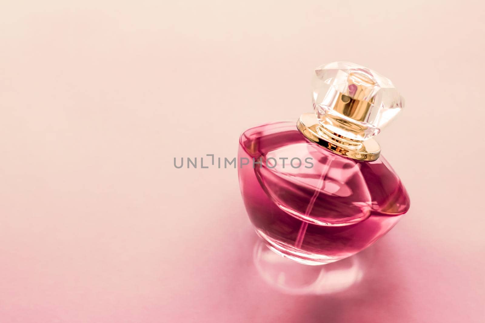 Perfumery, spa and branding concept - Pink perfume bottle on glossy background, sweet floral scent, glamour fragrance and eau de parfum as holiday gift and luxury beauty cosmetics brand design