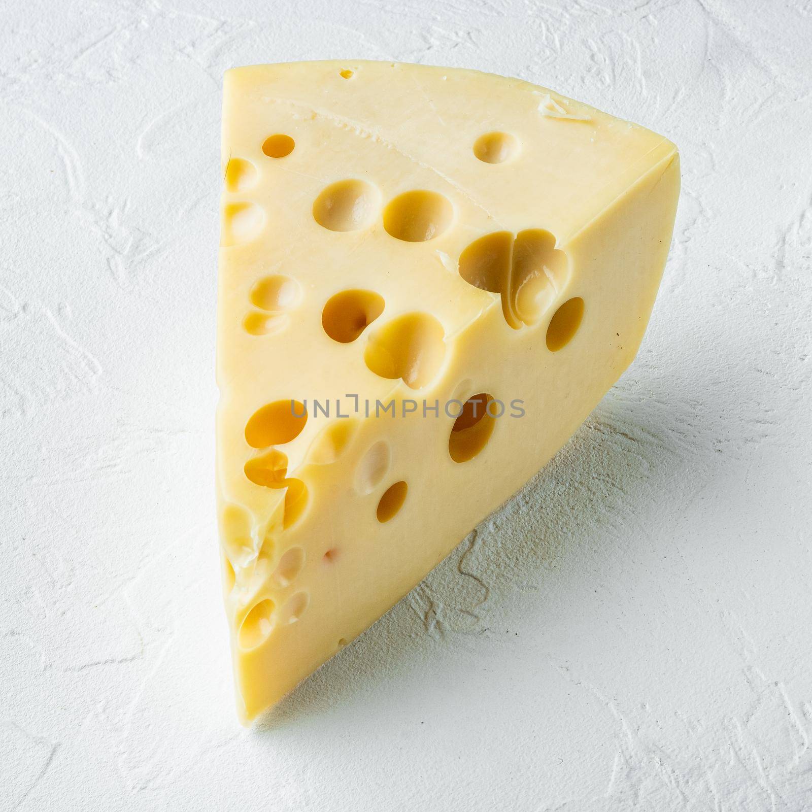 Maasdam cheese, on white stone surface, square format by Ilianesolenyi