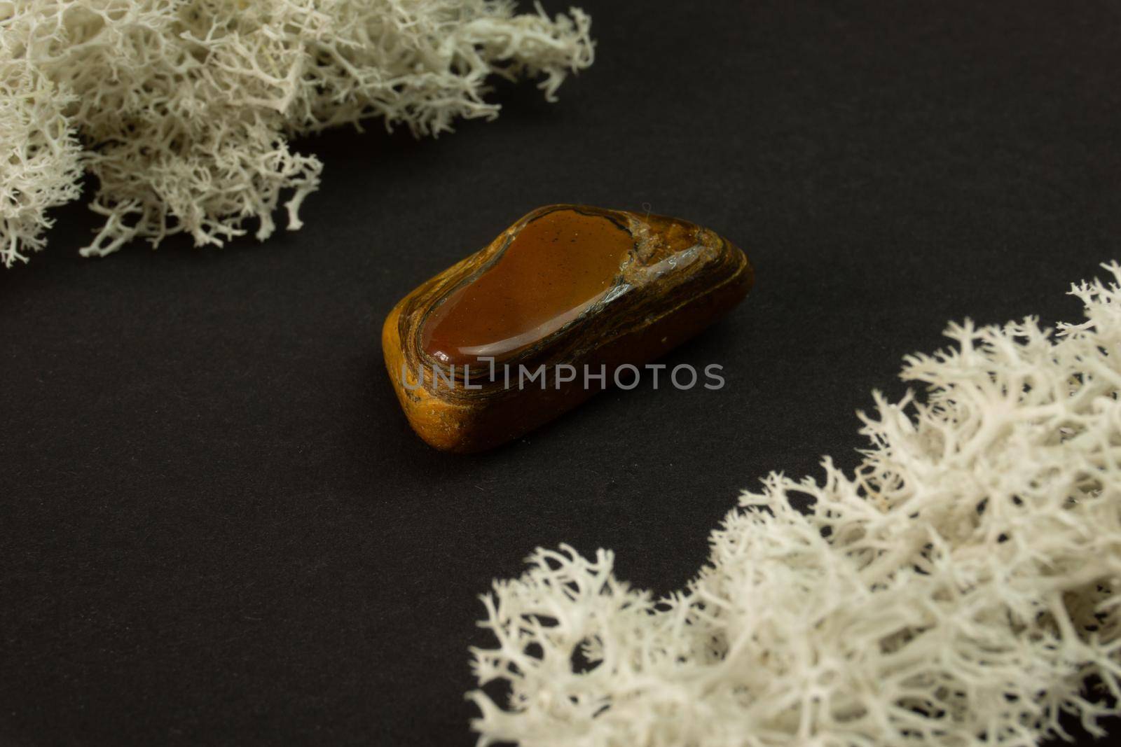 Tiger's eye stone from Republic of South Africa RSA. Natural mineral stone on black background. Mineralogy, geology, magic of stones, semi-precious stones and samples of minerals. Close-up macro photo.