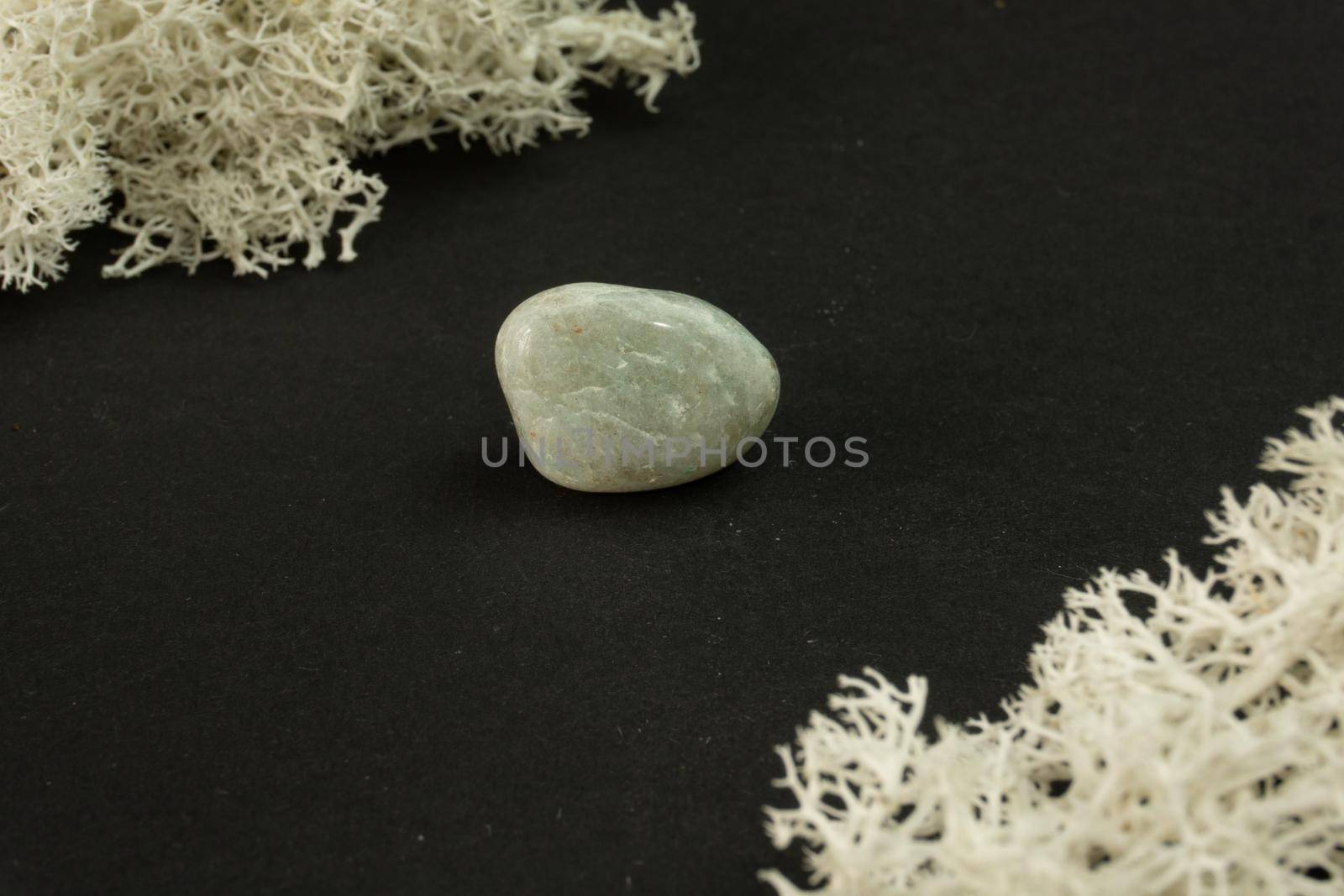 Jadeite from India. Natural mineral stone on black background. Mineralogy, geology, magic of stones, semi-precious stones and samples of minerals. Close-up macro photo