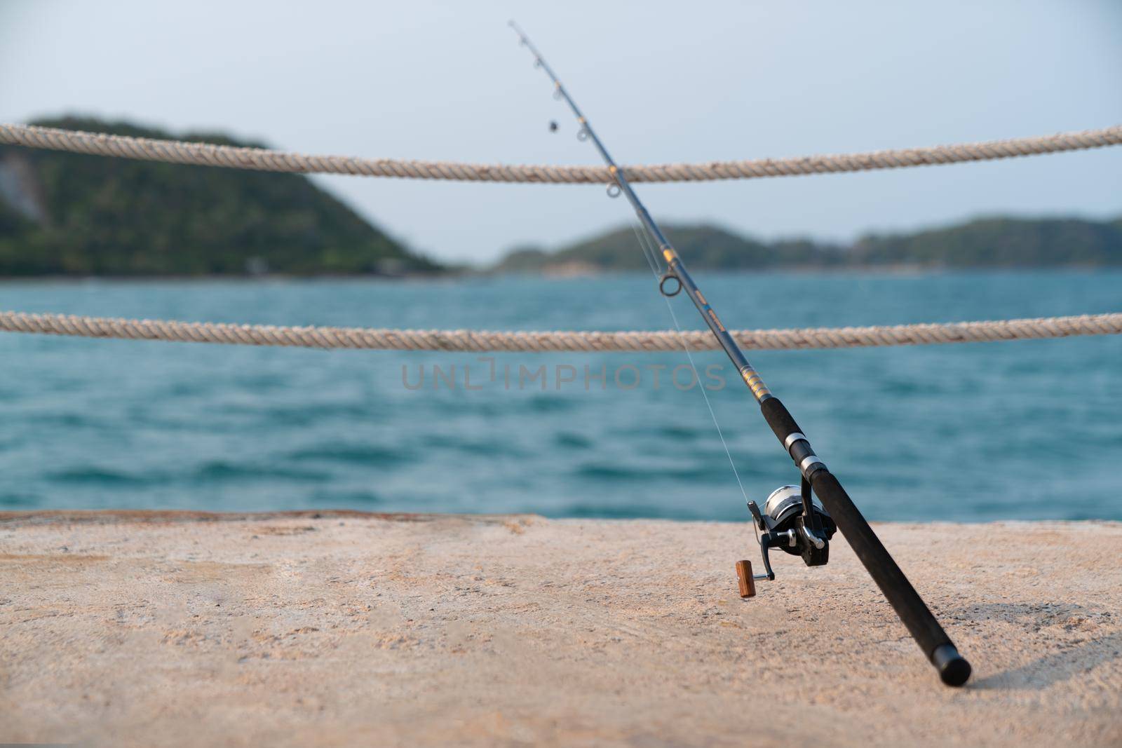 A fishing rod with sea background, fishing. by sirawit99
