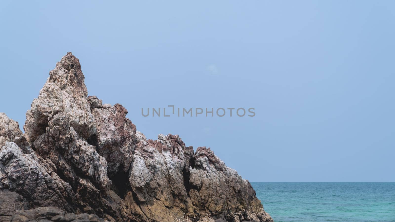 Tropical beach, rock and sand background with blue sky.