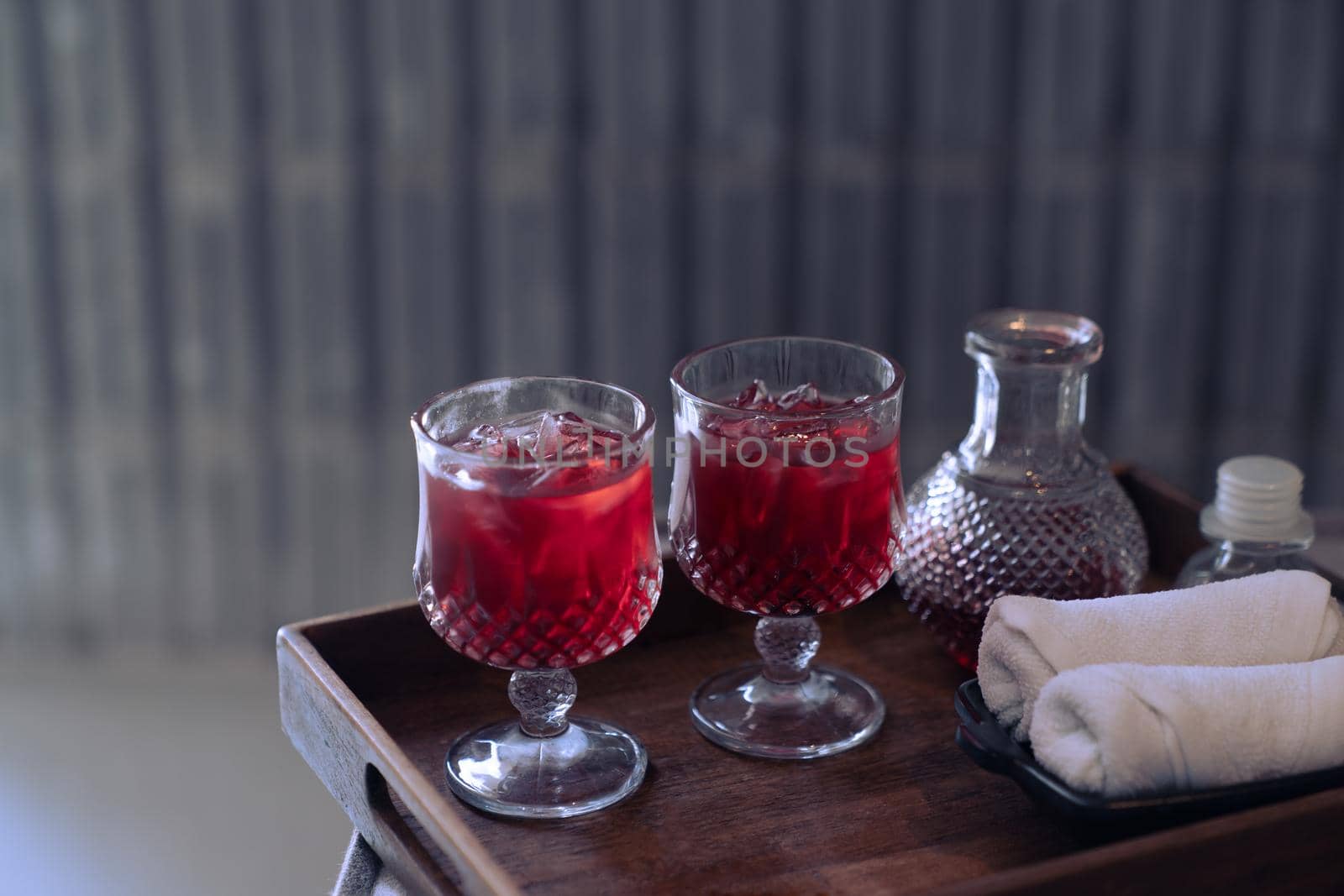 Welcome drink red mocktail and white towel served on wooden tray. by sirawit99