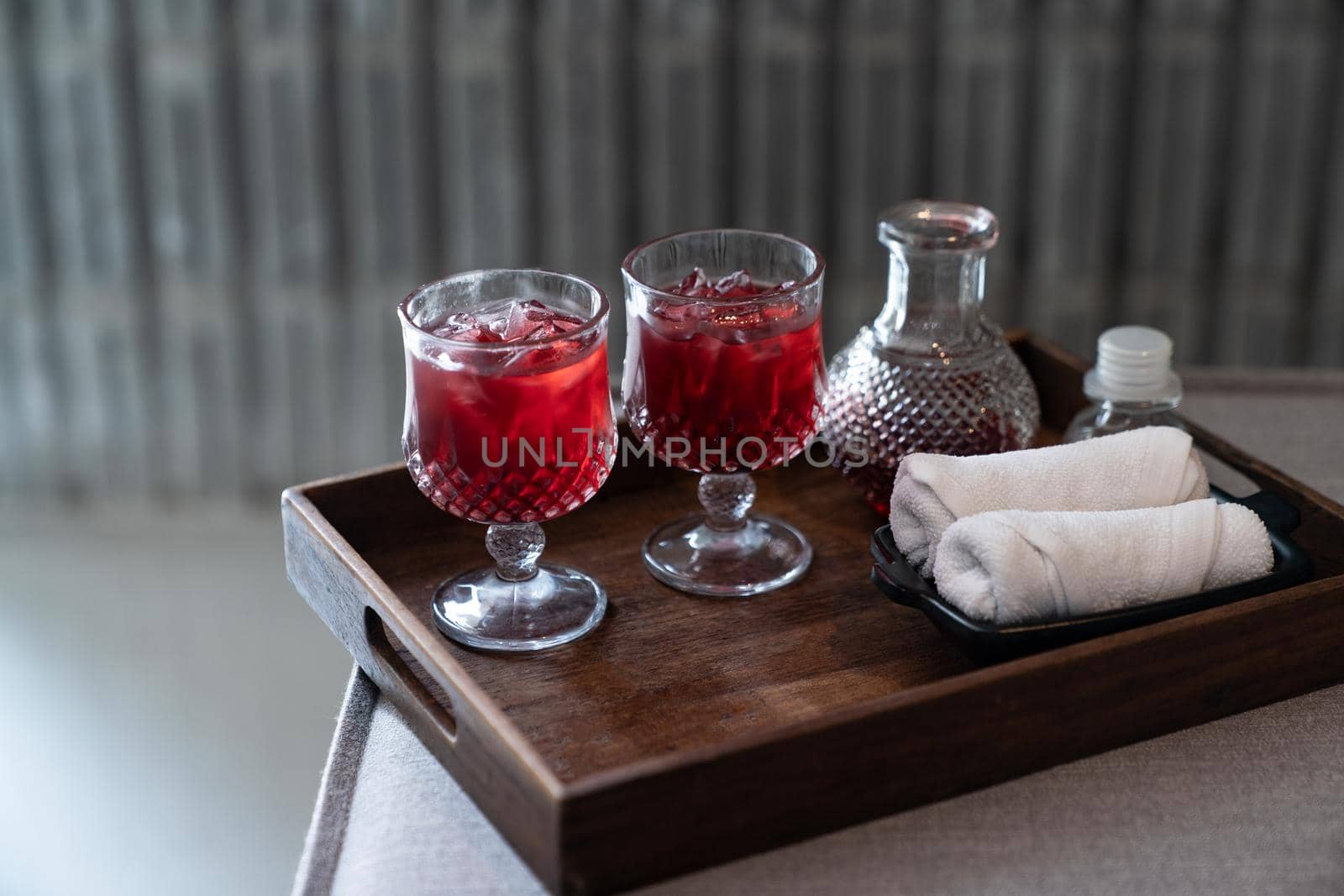Welcome drink red mocktail and white towel served on wooden tray. by sirawit99