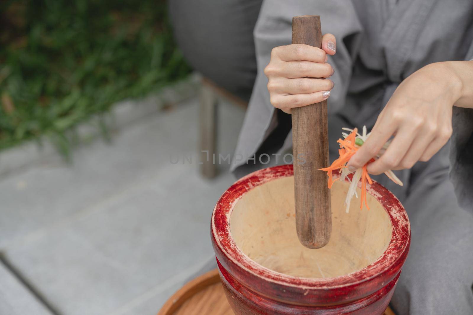 Woman hand making thai food call papaya salad or Som Tam, mixing and pounding in a mortar. by sirawit99