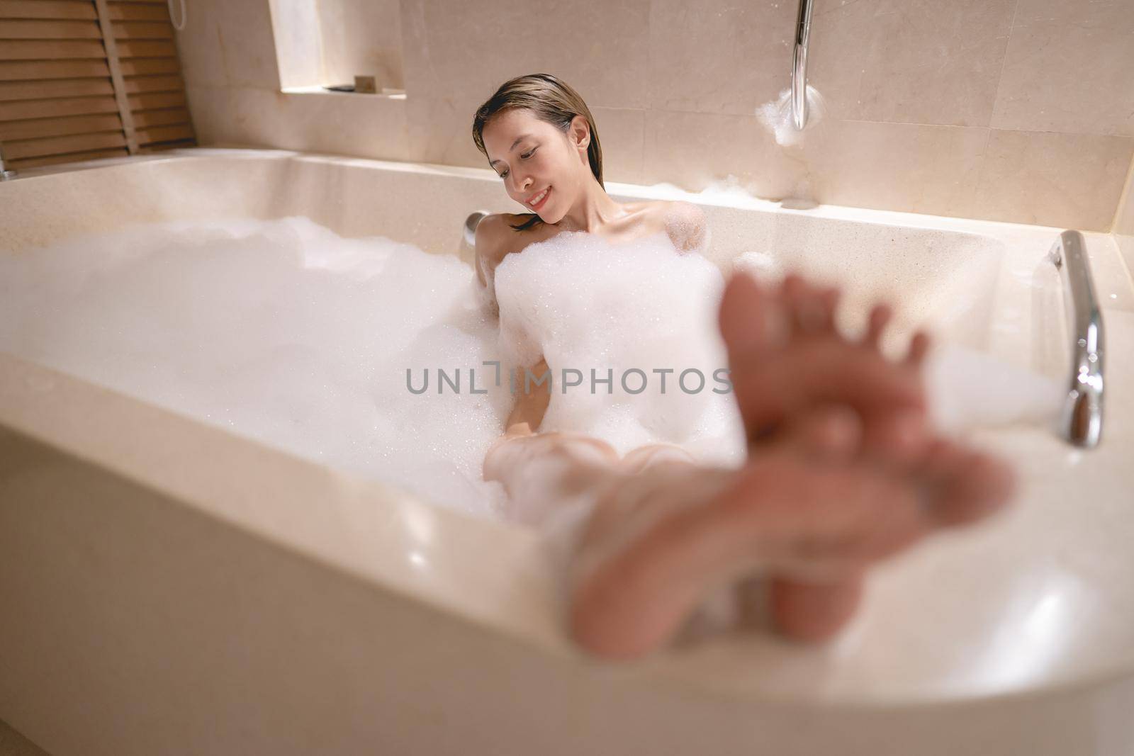 Woman lying in bathtub and relaxing with bubble foam. by sirawit99