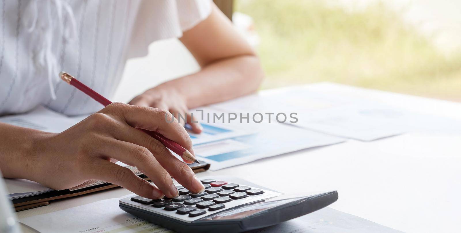 Business woman or accountant working in finance and accounting Analyze financial budget - work from home concept by wichayada