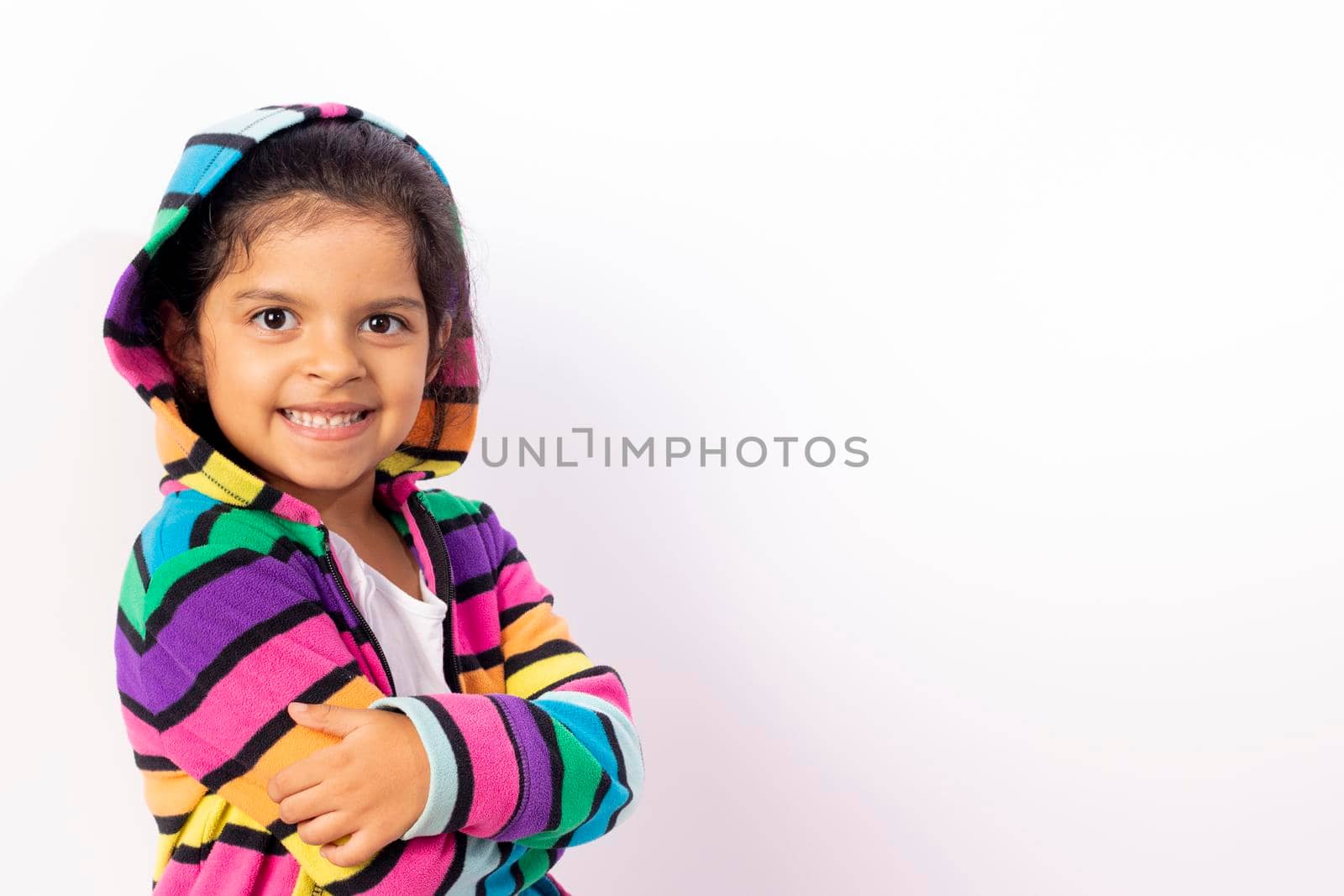 Little girl with cute face with her colorful sweater, with a white background