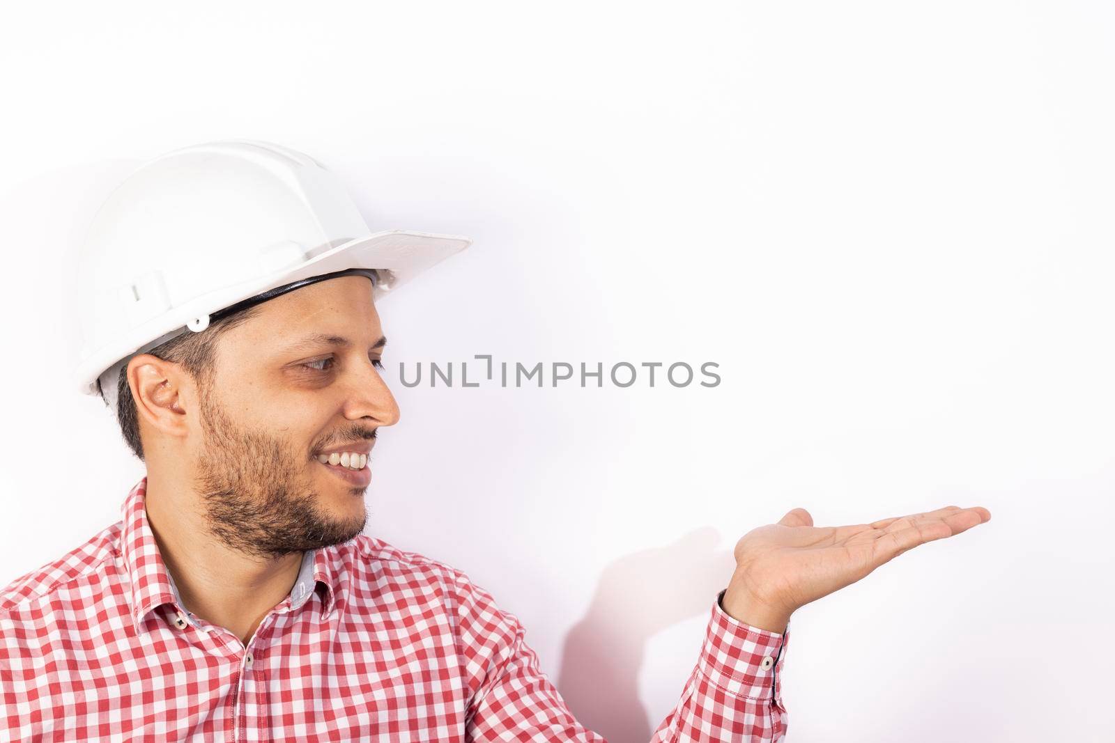 Handsome builder worker with white helmet showing his hands