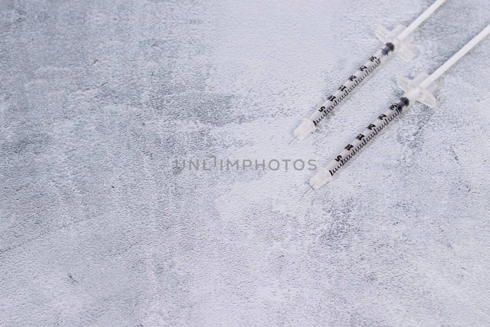 Two syringes on a gray marbled background