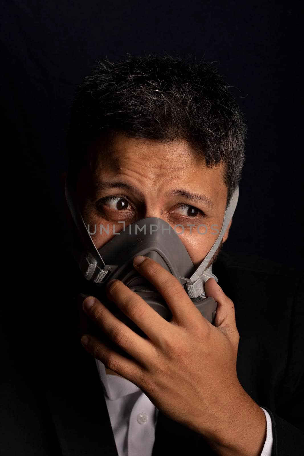 Young handsome with fear and industrial mask to prevent the spread of contagious viruses or chemical gases