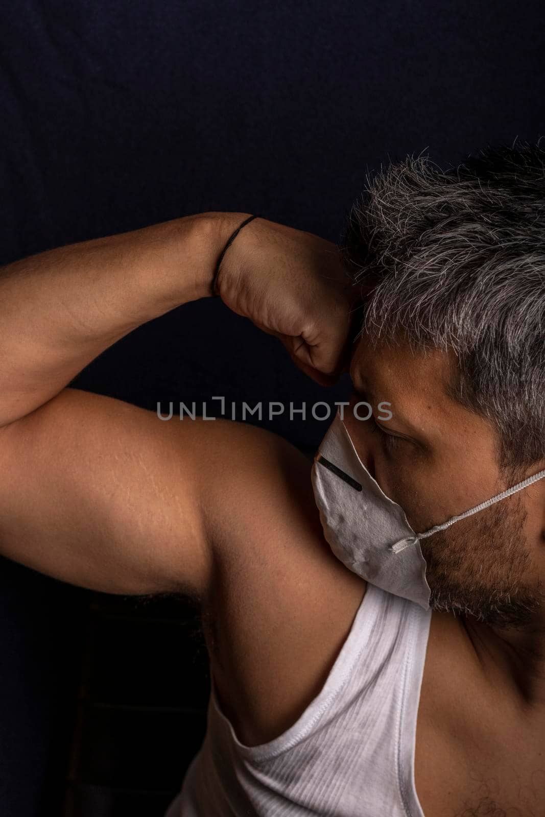 Young man with medical mask demonstrating his strength