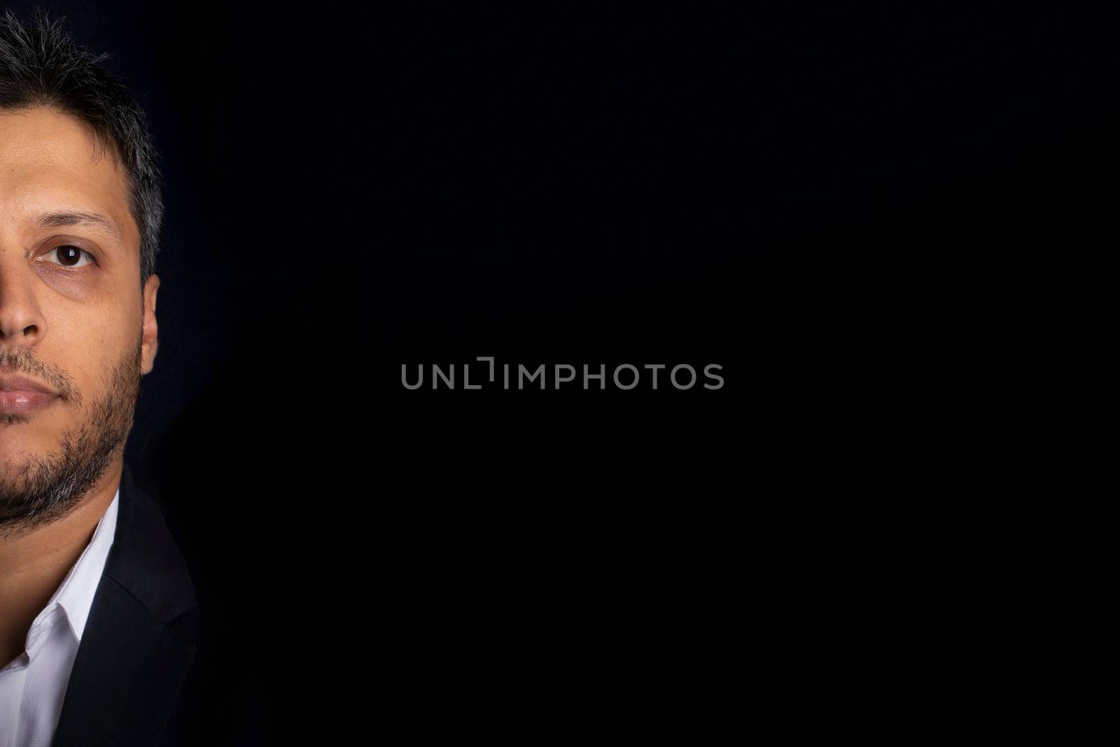 Half face portrait of handsome man smiling with little beard and with black background by eagg13