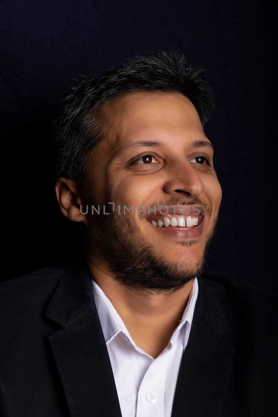 Portrait of handsome man smiling with little beard and with black background by eagg13