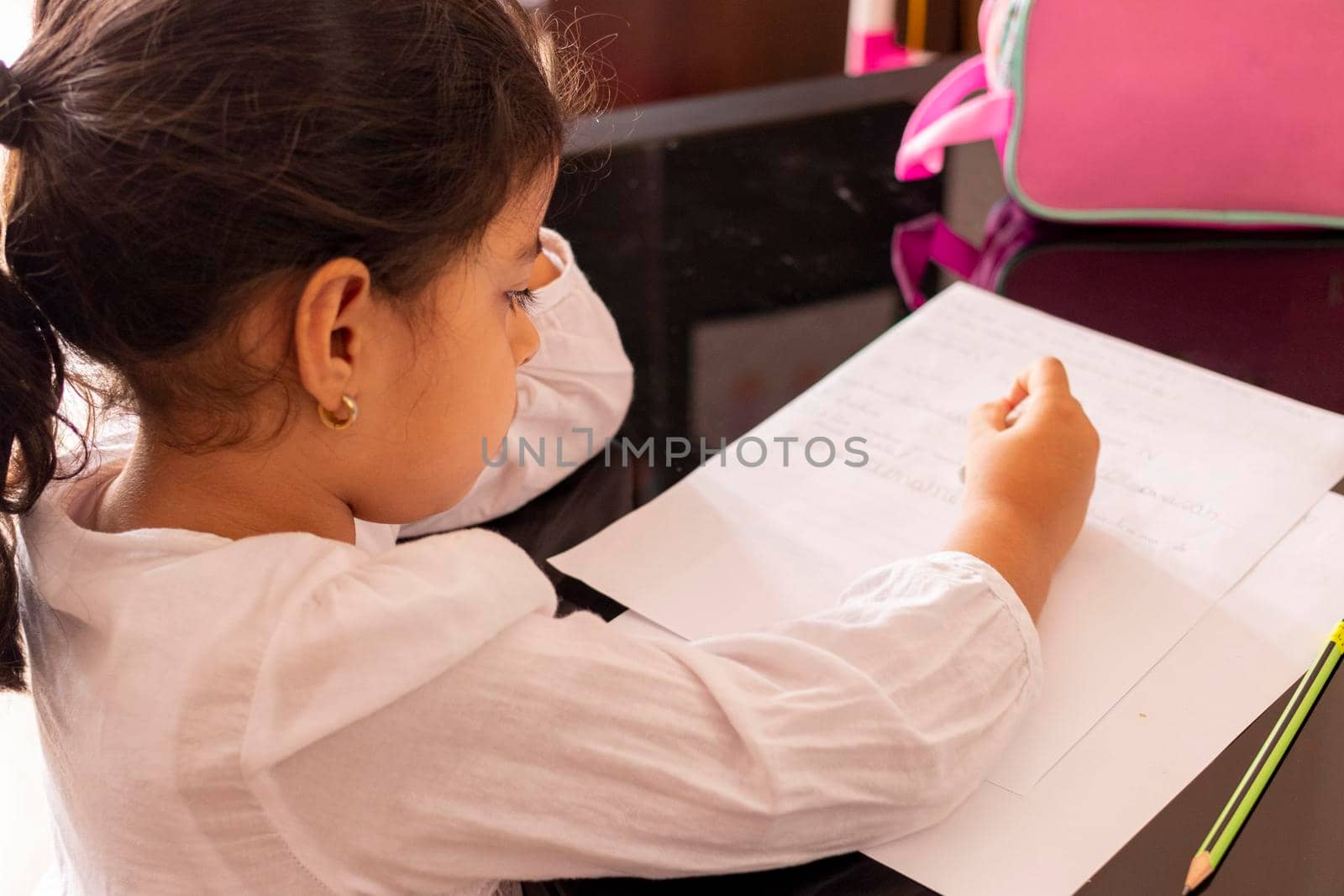 Girl is writting at a small table