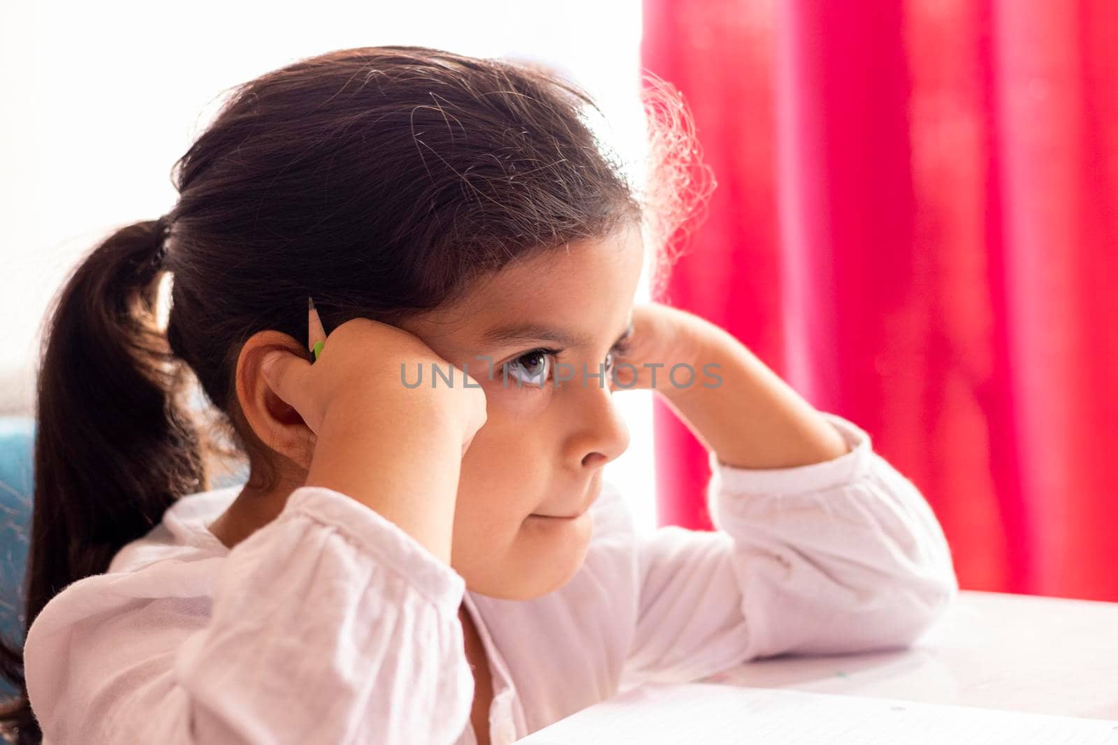 Girl is drawing and painting at a small table