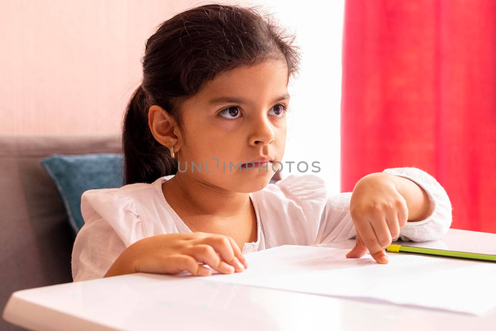 Girl is drawing and painting at a small table