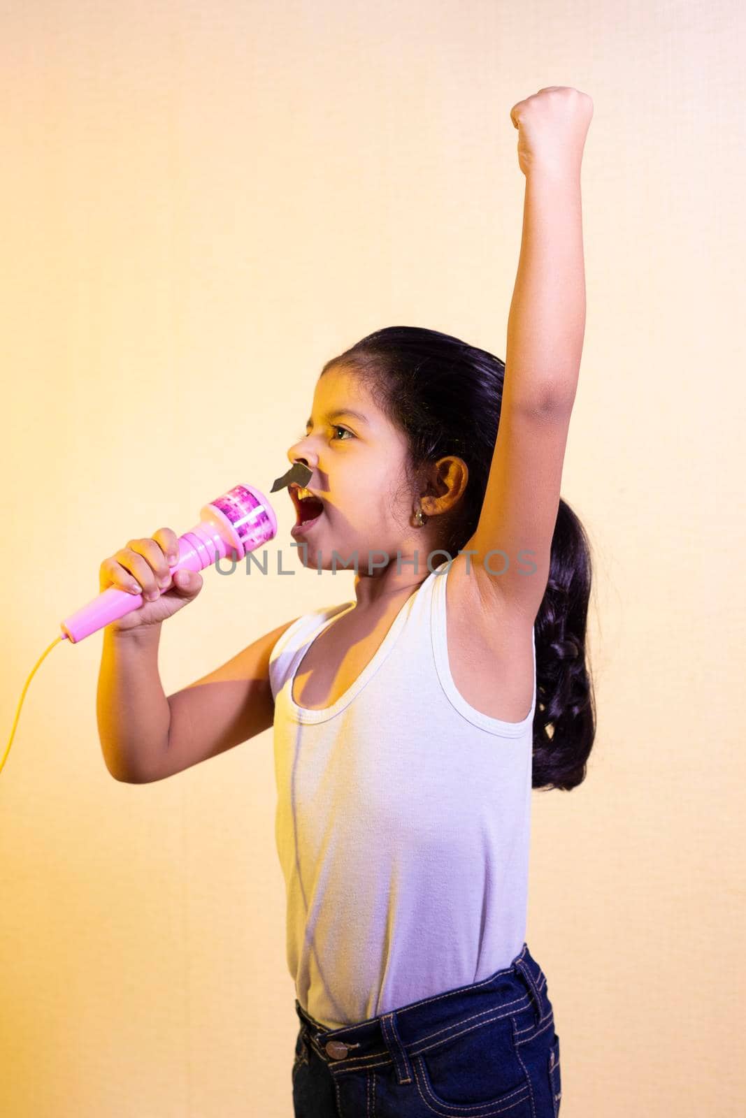 Little girl with a mustache singing using her microphone