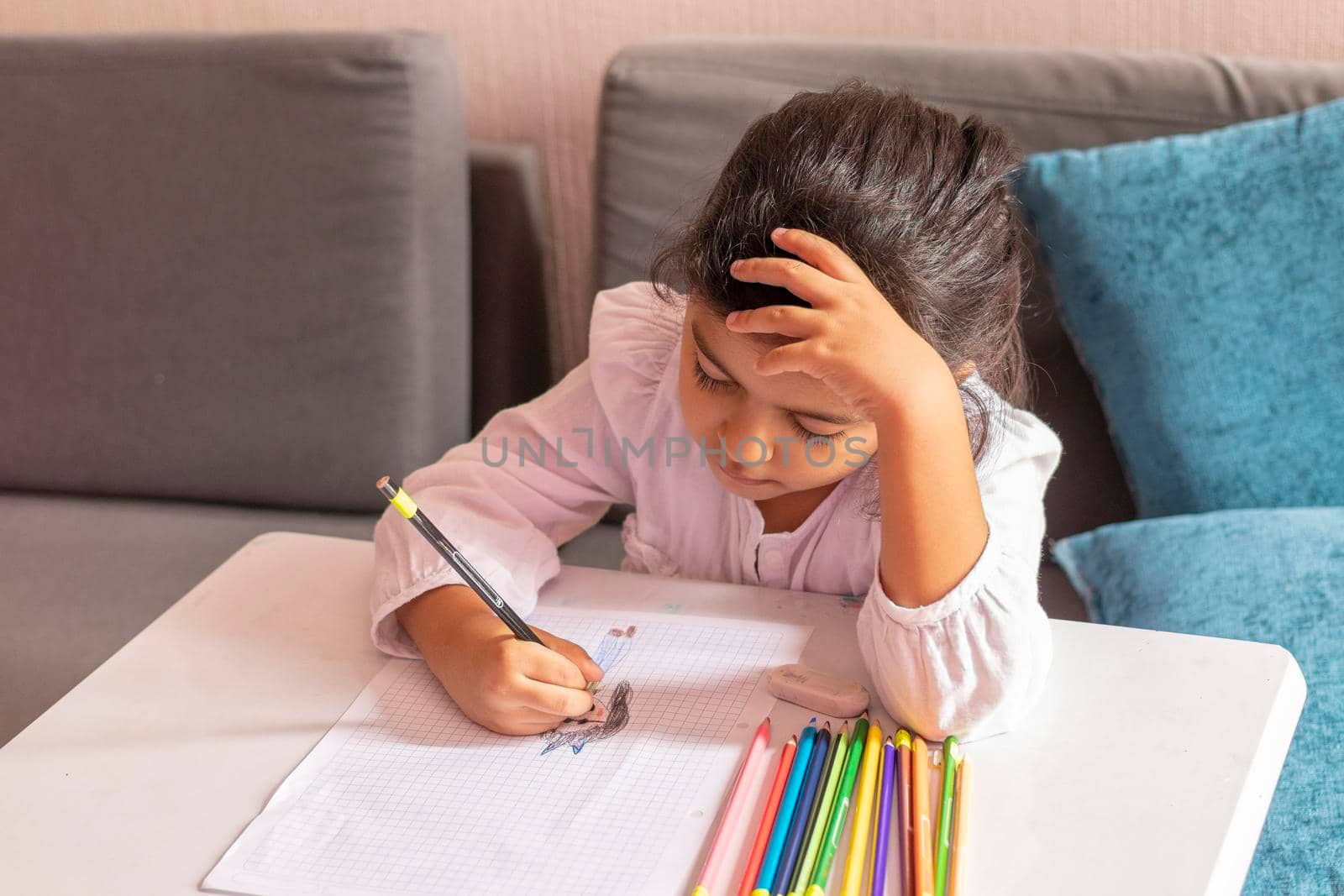 Girl is drawing and painting at a small table