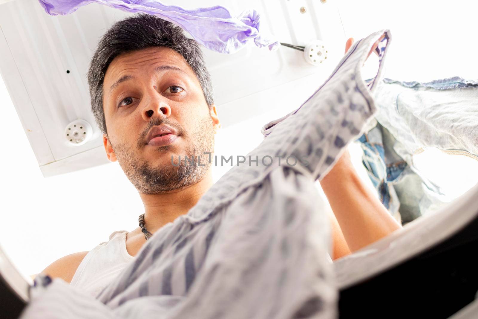 Bearded man using washing machine at home by eagg13