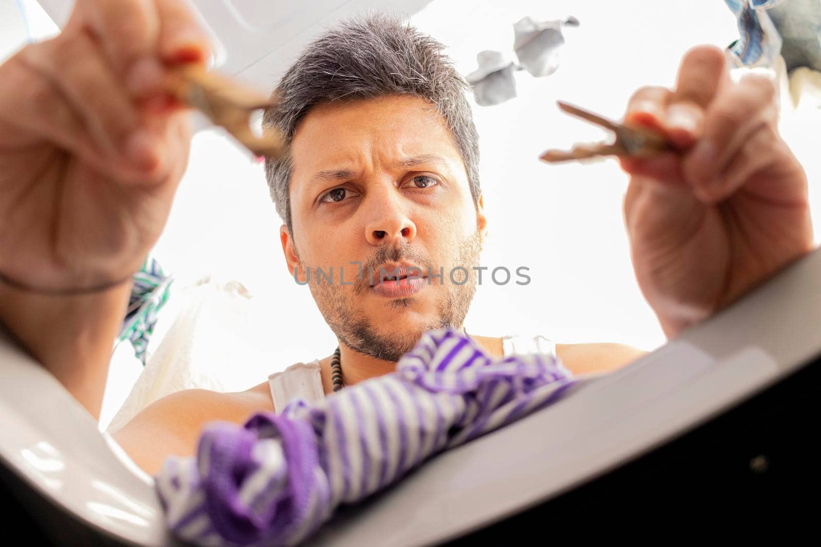 Bearded man using washing machine at home