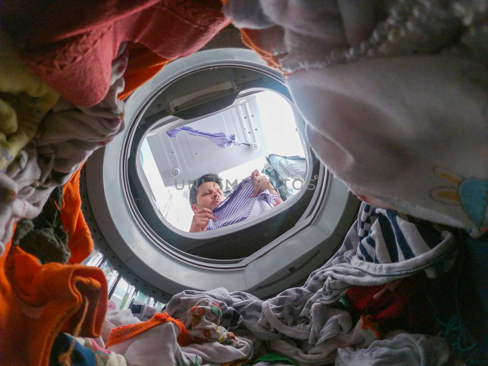 Bearded man using washing machine at home