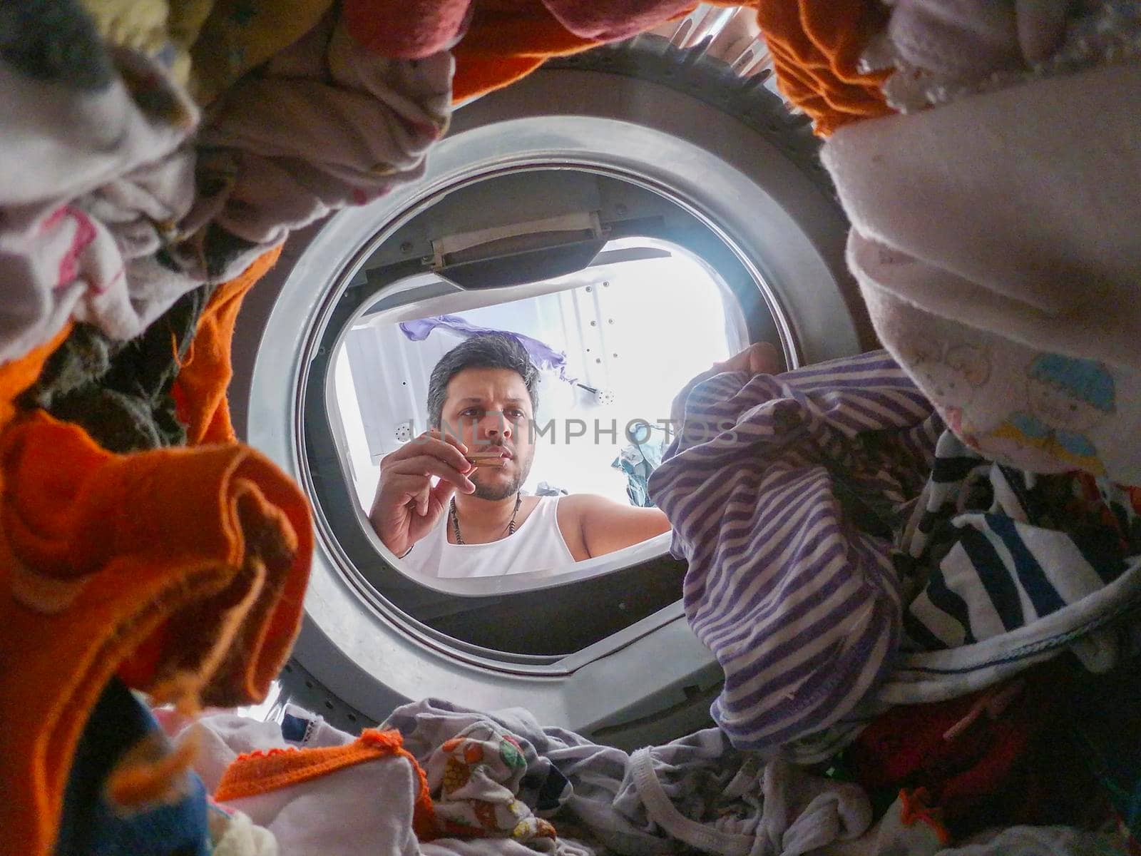 Bearded man using washing machine at home