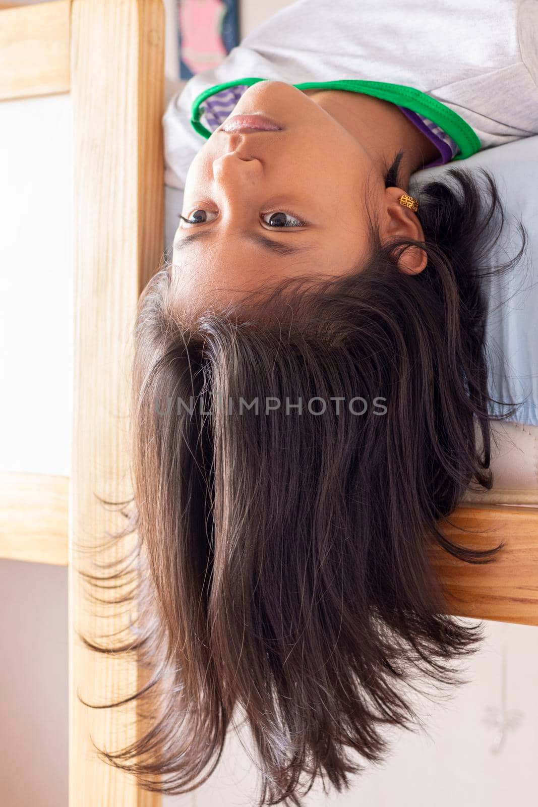 A girl is upside down looking down from the top of her bunk by eagg13