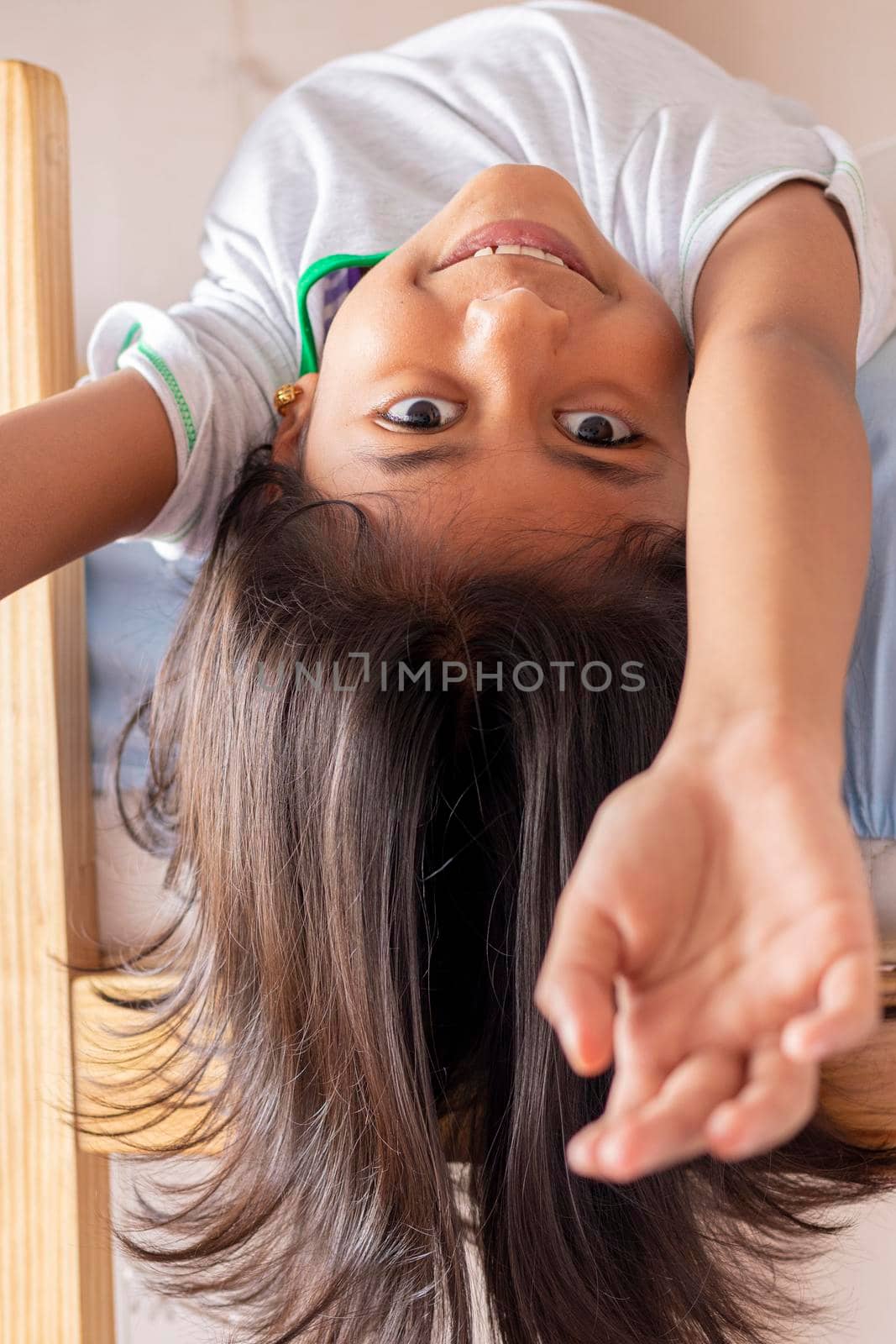 A girl is upside down looking down from the top of her bunk by eagg13