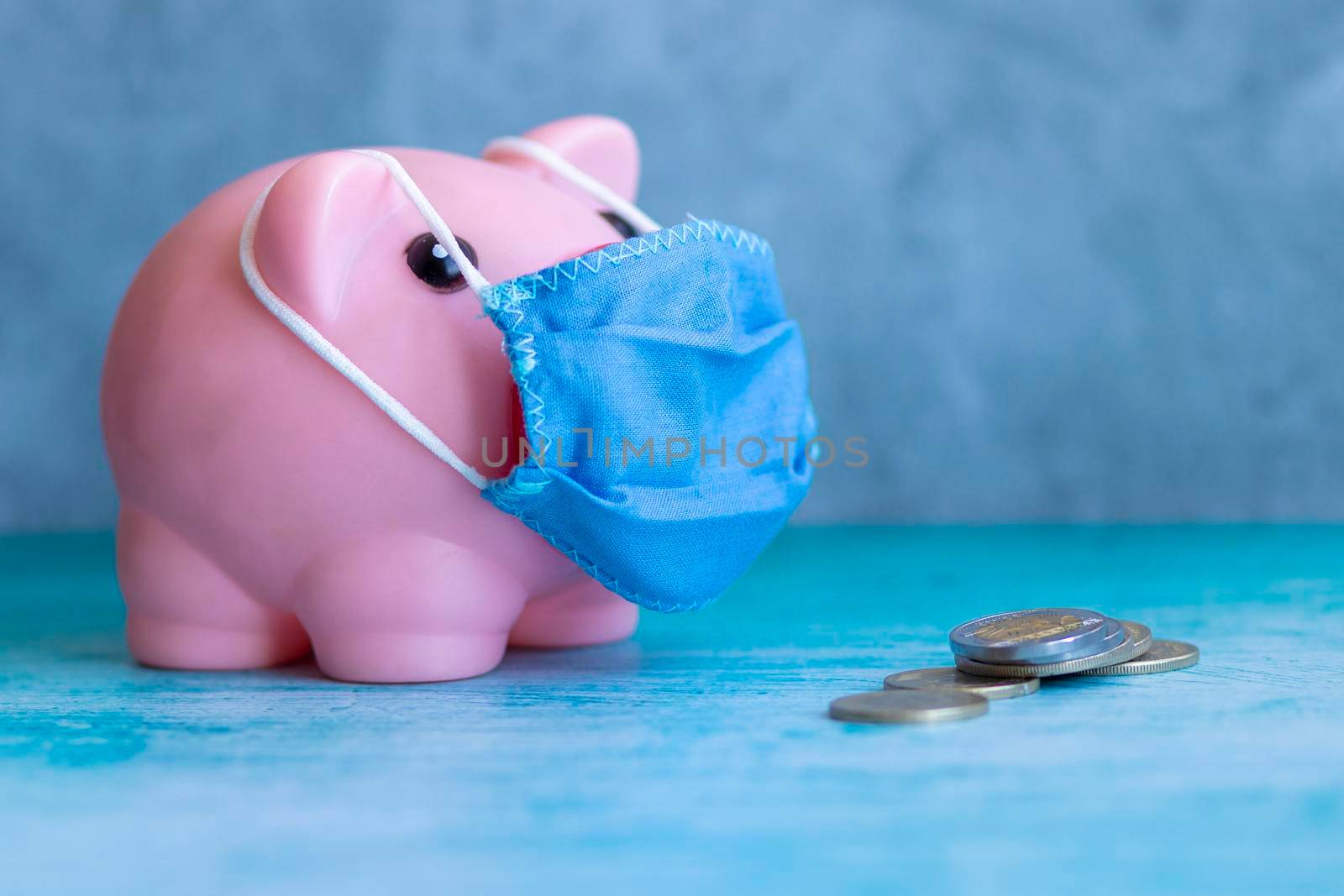 Pink piggy bank with medical mask