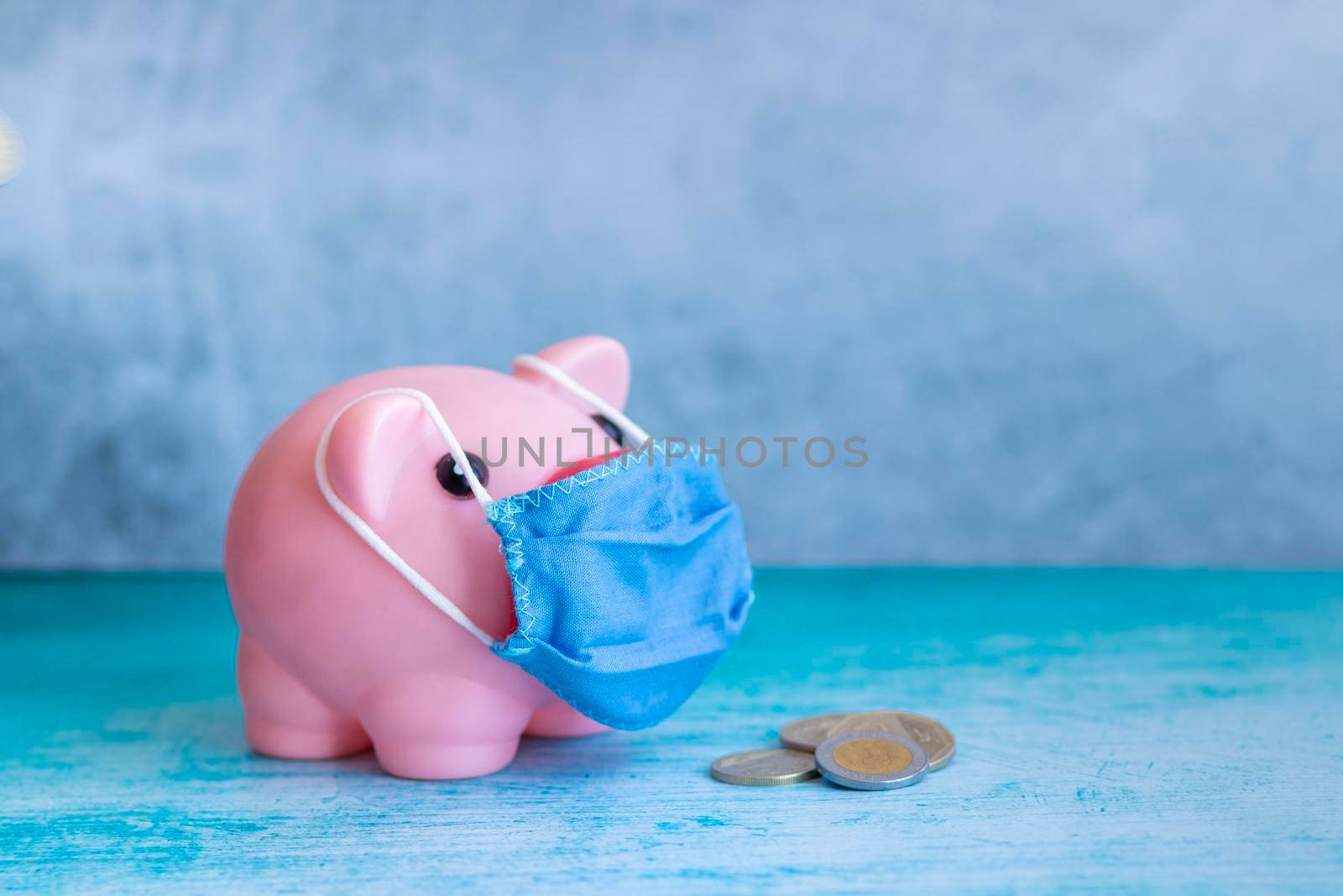 Pink piggy bank with medical mask