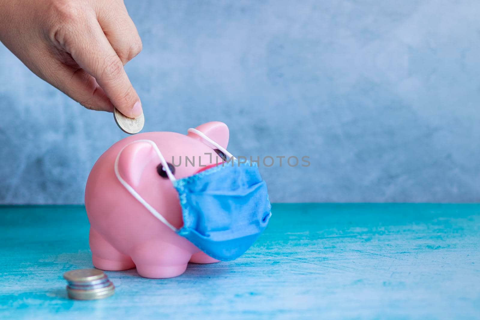 Coins falling into pink piggy bank