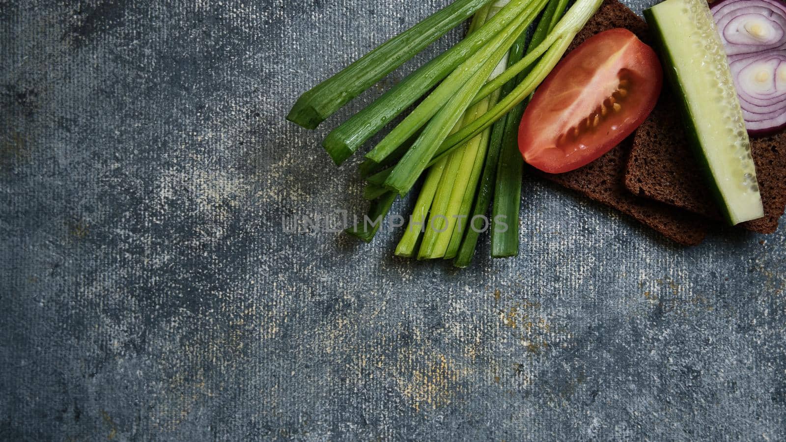 Bread with red onions, green onions, cucumber and tomato wedges