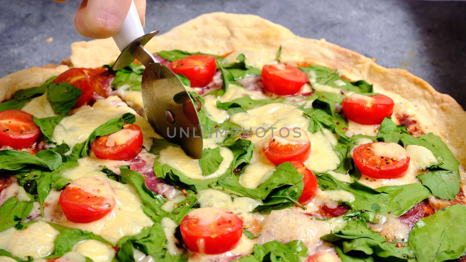 Pizza with cheese, tomatoes, spinach and smoked sausage