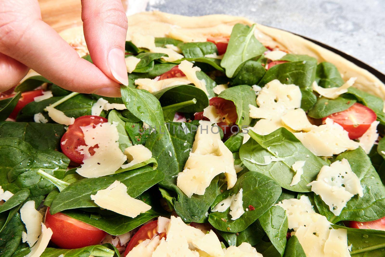 Pizza with cheese, tomatoes, spinach and smoked sausage