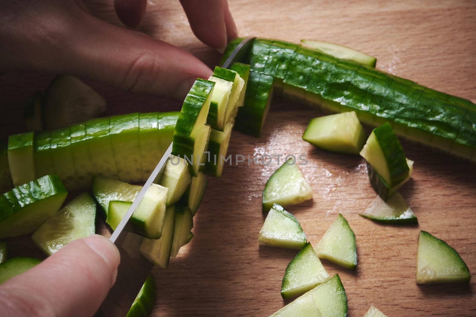 Chopping a cucumber on a cutting board